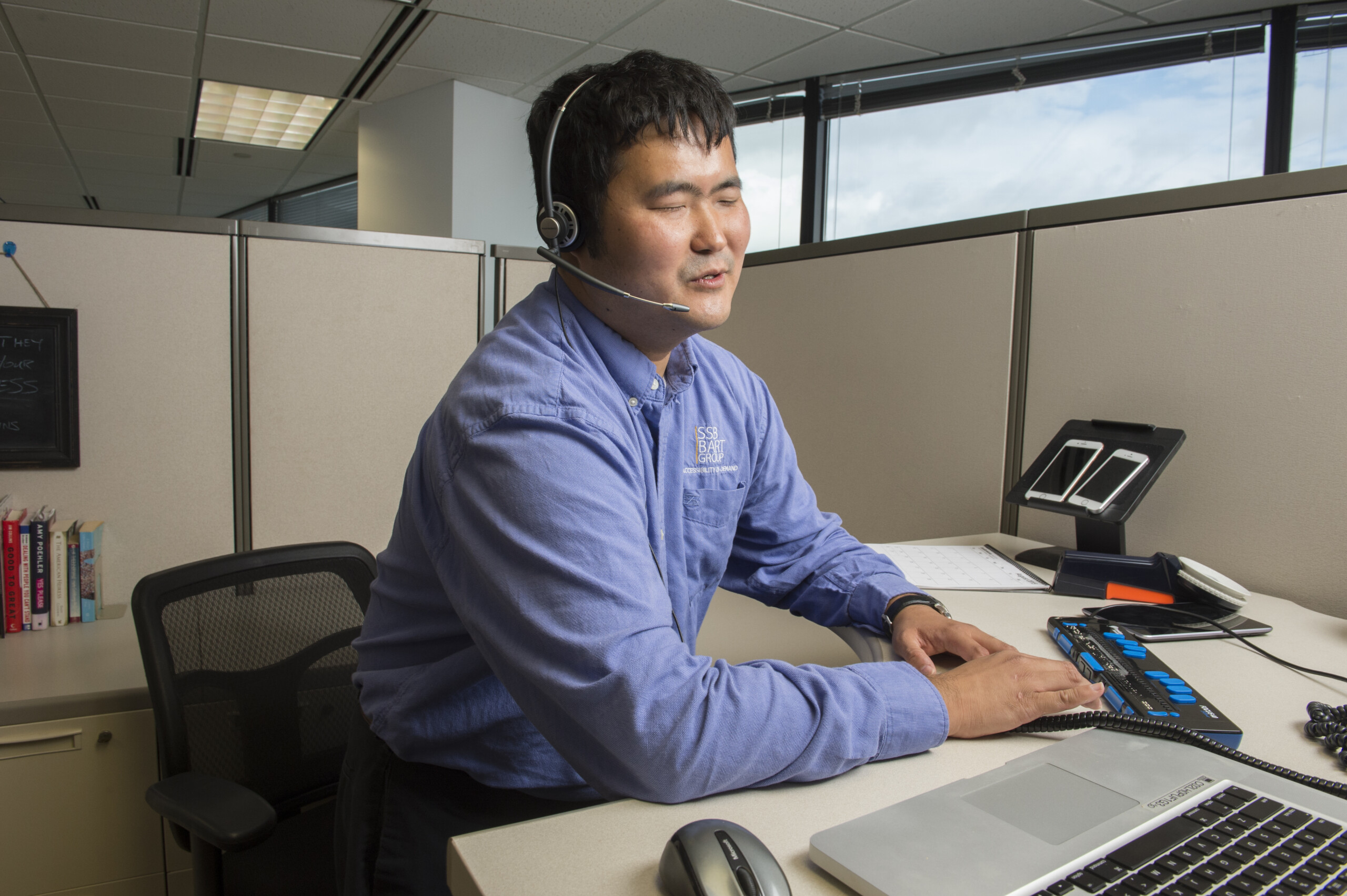 Blind Employee using technology in cubicle Blind Employee using technology in cubicle